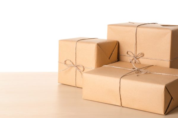 parcel-gift-boxes-on-wooden-table-against-white-background-1