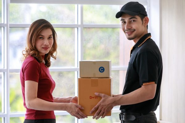 smiling-asian-courier-man-delivers-packages-to-asian-female-customer-at-home-parcel-delivery-and-shipping-door-to-door-e-commerce-business-concept-1